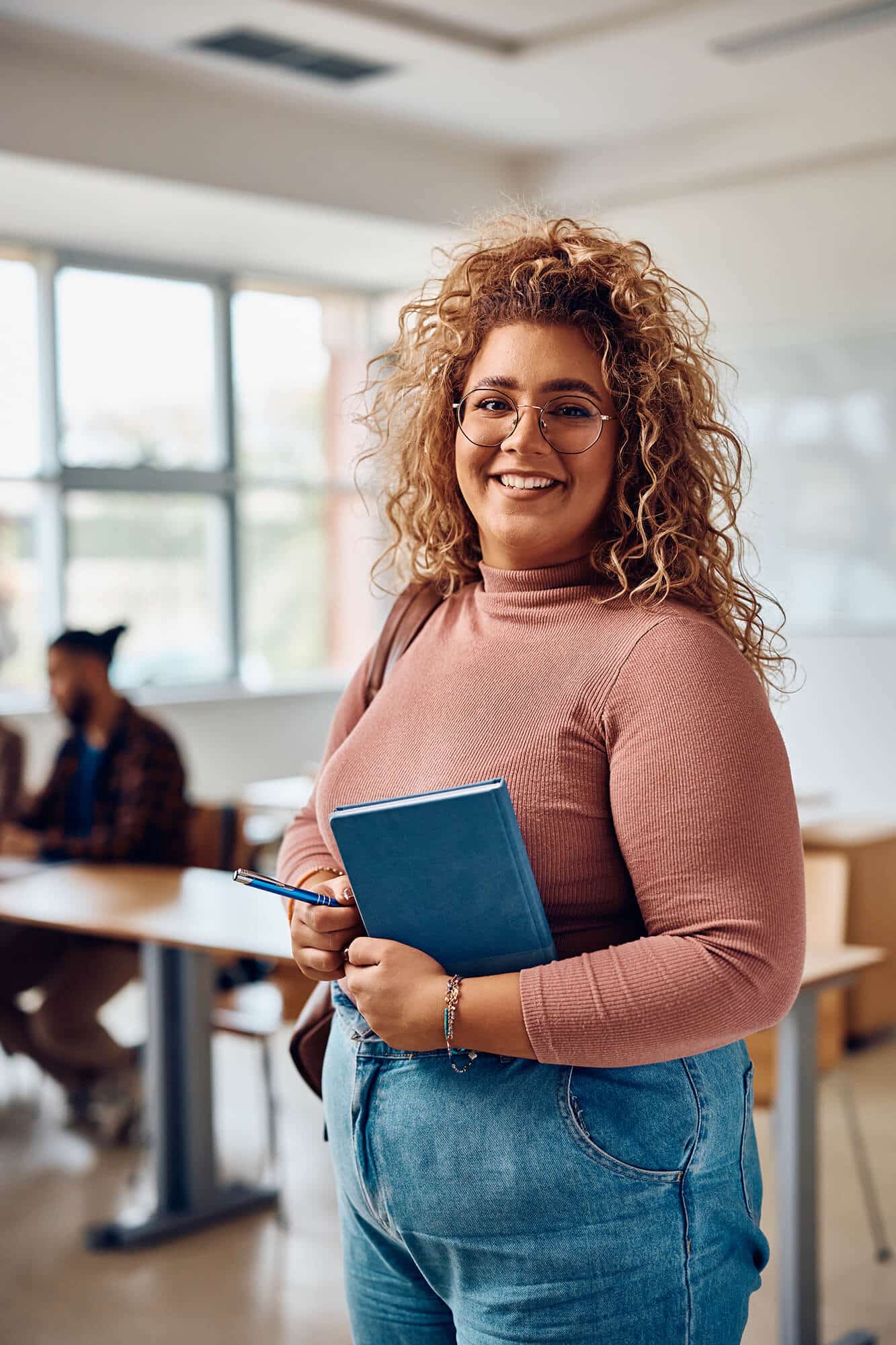 happy-female-student-standing-in-the-classroom-and-2023-11-27-04-56-53-utc