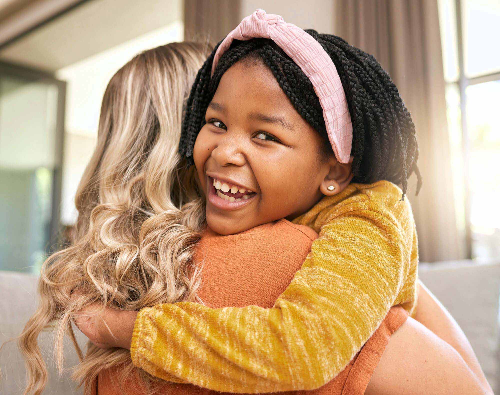 hug-mother-and-adopted-black-girl-in-living-room-2023-11-27-05-23-56-utc